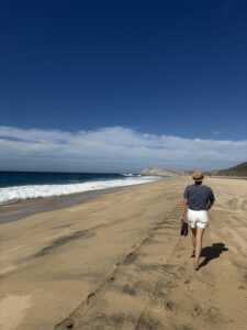 One woman walking down the beach for a little solitude by the Pacific ocean
