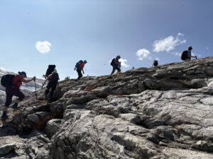 Women hiking along a rocky lateral moraine during a 2025 Revelstoke women’s wellness retreat in the Monashee Mountains near Revelstoke, British Columbia.