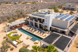 View of the retreat centre from above. It includes the main building, hot tub and pool. Lawn chairs line the pool.
