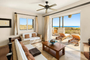 Picture of a living room looking out the open doors at the beach and pacific ocean