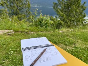 Picture of a sketch book with the lake behind it.