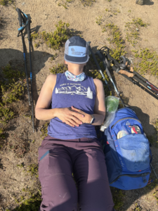 Woman lying on the ground taking a bit of a nap during a hike