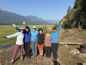 A group of 6 women with hands up.