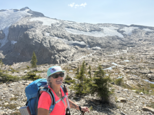 A woman wearing a Revelstoke Retreats hat in front of Blanket Glacier